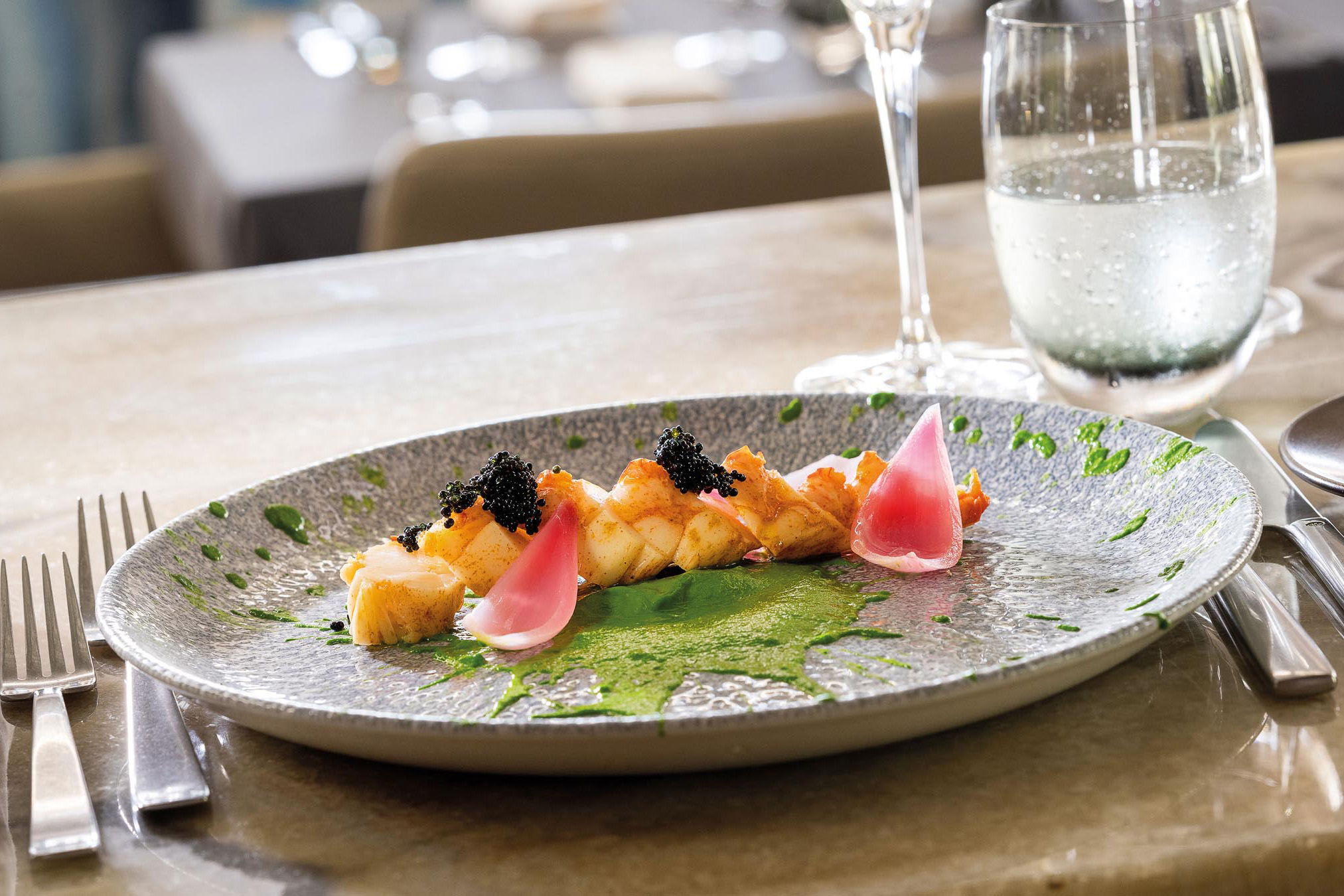 Prato com molho verde e abacaxi com caviar por cima