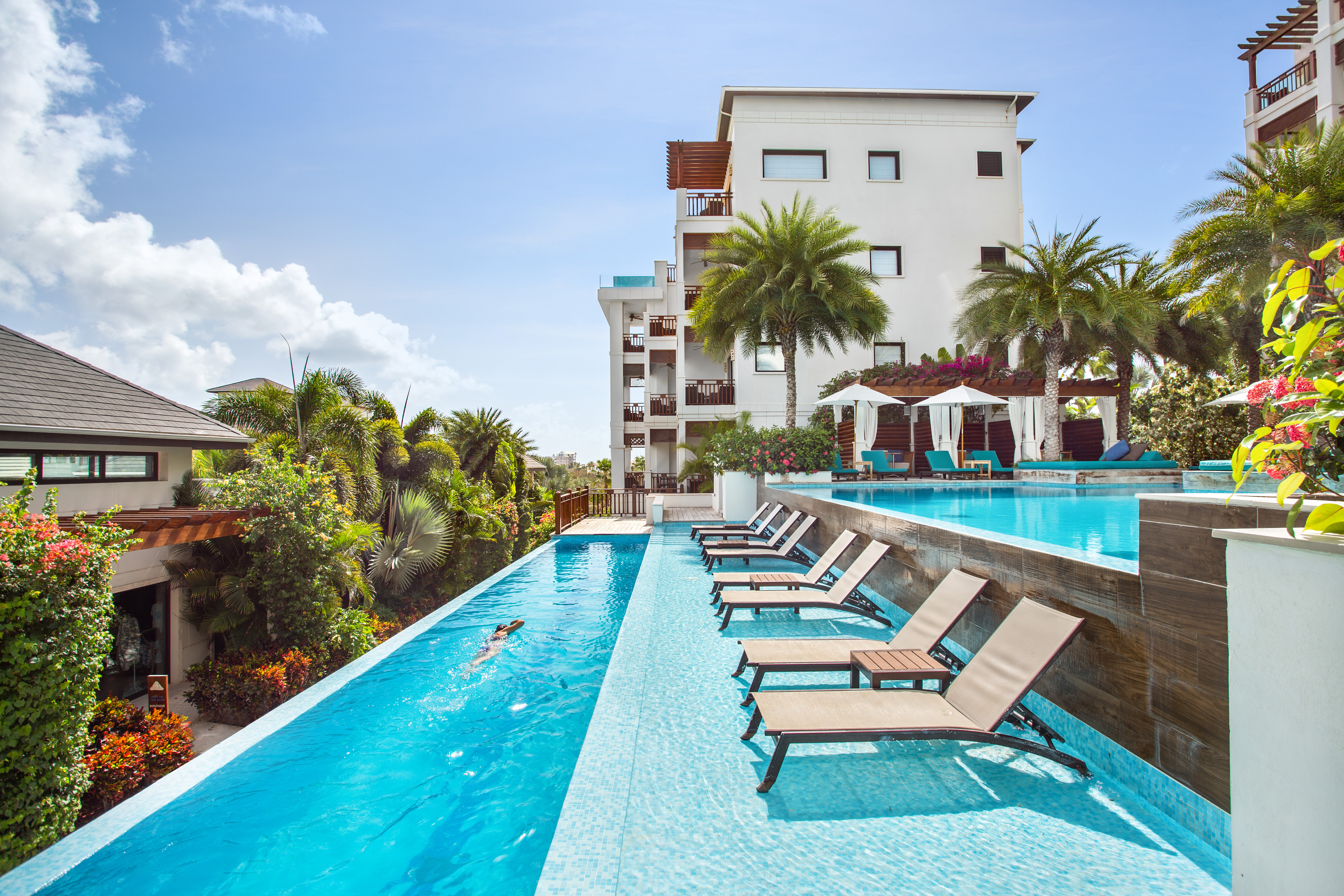 Pool beside lounge chairs and view of resort in background