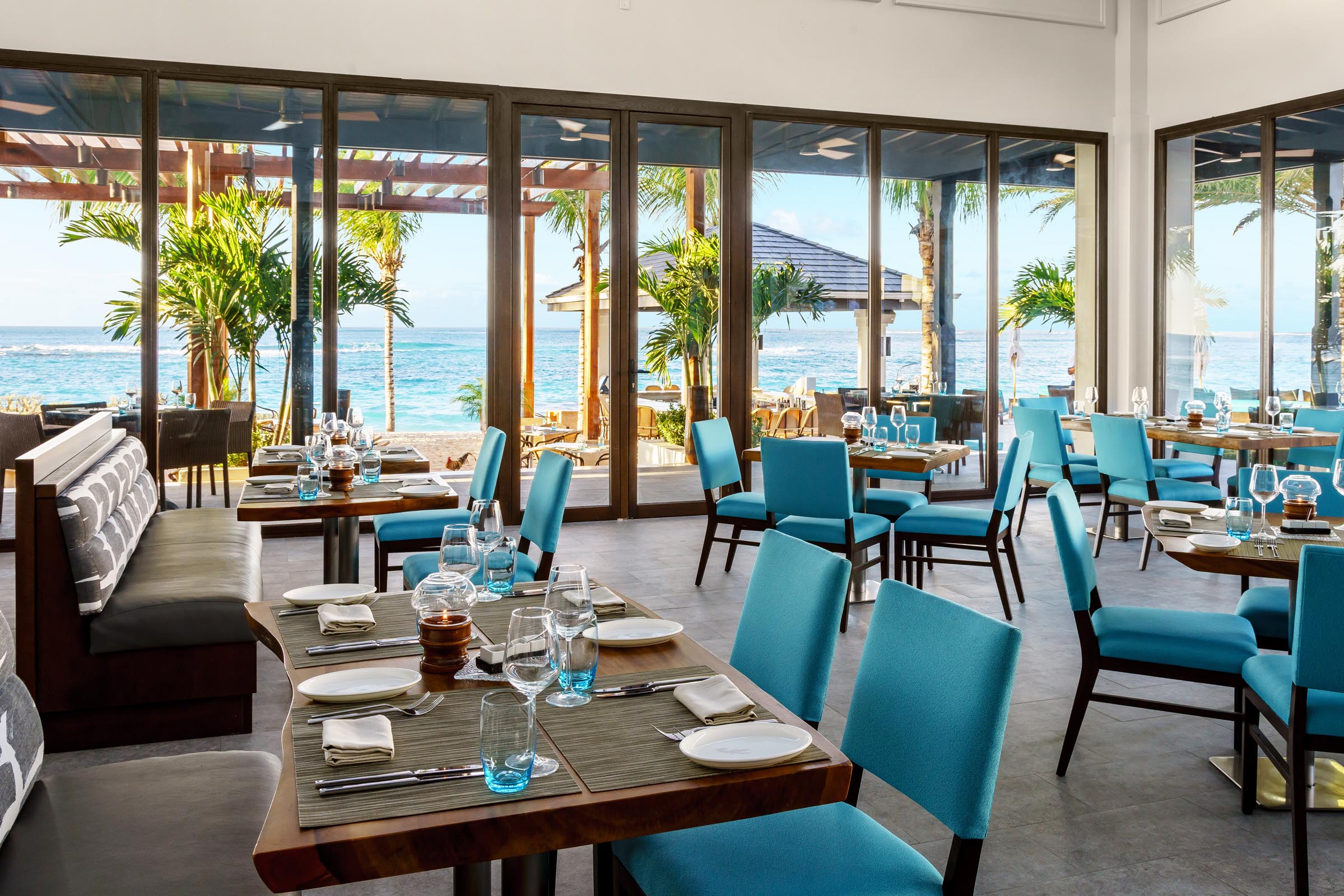 Cadeiras azuis com mesas quadradas marrons no restaurante