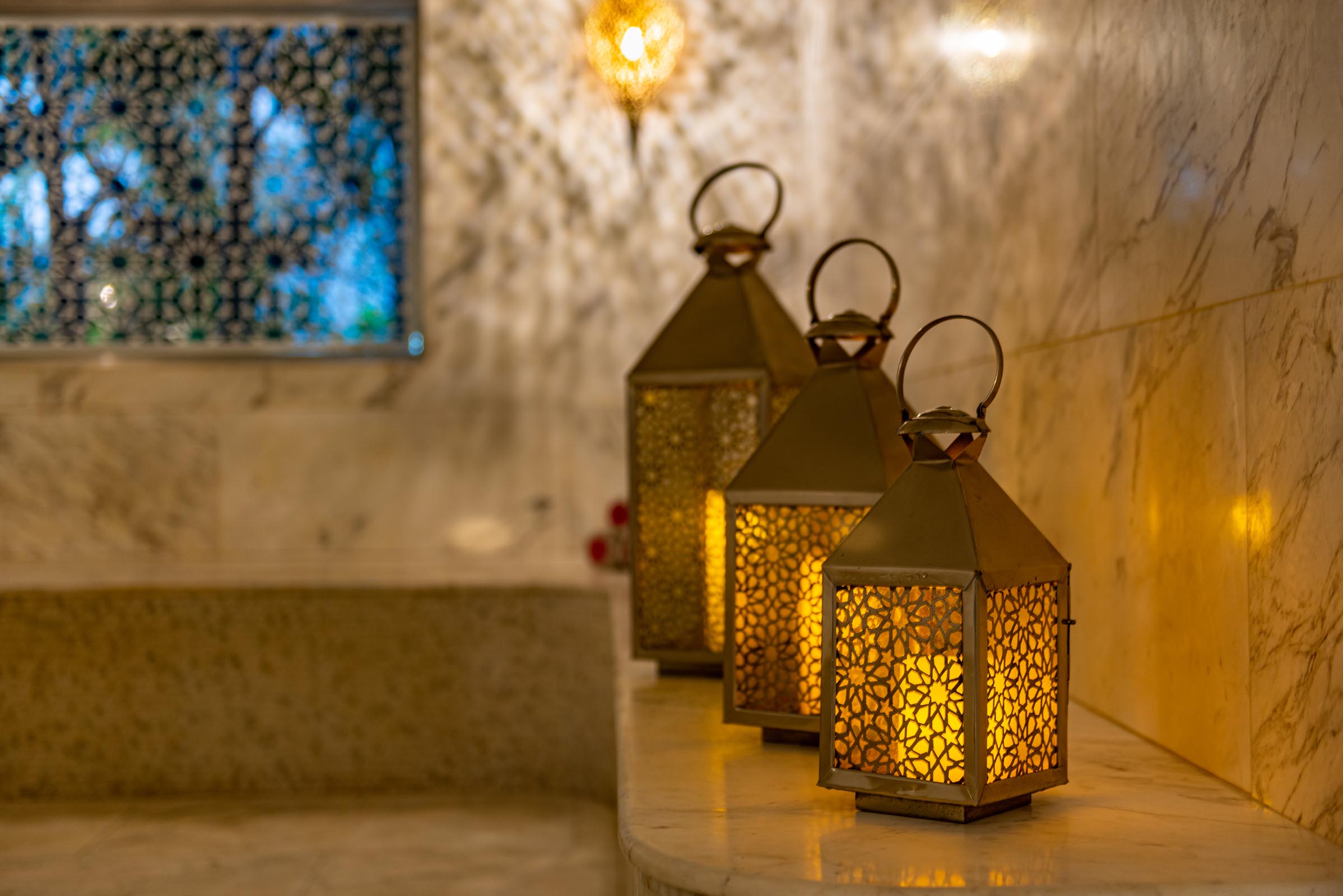 Lanternas sentadas na borda de mármore em Hammam